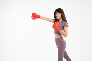 Portrait of beautiful Asian woman standing smile wearing the red boxing gloves,  studio shot isolated on white background, Concept of fitness, exercise and healthy photo