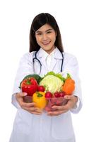 médico o nutricionista con fruta fresca naranja, manzanas rojas y verdes y sonrisa en la clínica. concepto de dieta saludable de alimentos nutritivos como receta para una buena salud, la fruta es medicina foto