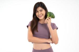 Portrait of young happy and healthy Asian woman holding Block Curry and looking at camera on white Isolated background. Concept of vegetarian diet, healthy lifestyle with healthy food. photo