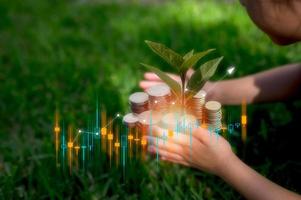 ahorro y inversión estrategia, niño planta un árbol en borroso apilado de aud monedas y técnico comercio grafico en concepto de crecimiento educación fondo para niños. foto