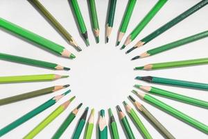 green pencils lined up in a circle on a white background. photo with round frame for copy space
