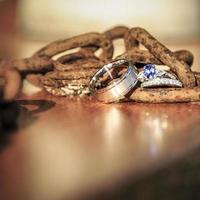 Wedding and blue sapphire engagement ring on old rusty chain. photo