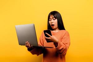 en línea comunicación concepto asiático niña utilizar ordenador portátil a hogar amarillo estudio foto ella es contento a gastar su gratis hora en línea mientras chateando con amigos en social redes, compras o trabajando en línea.