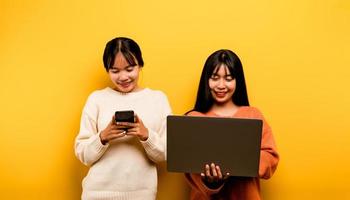 dos asiático mujer trabajando en ordenador portátil y teléfono. a el mismo hora dos de ellos fueron comunicado en línea y demostración contento sonrisas