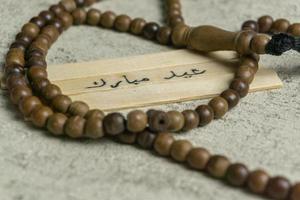 islámico citas. eid Mubarak palabras escrito en de madera palo. foto