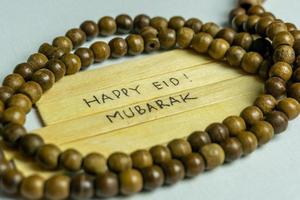 Islamic quotes. Eid Mubarak words written on wooden stick. photo