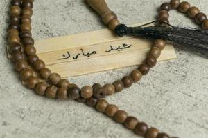 Islamic quotes. Eid Mubarak words written on wooden stick. photo