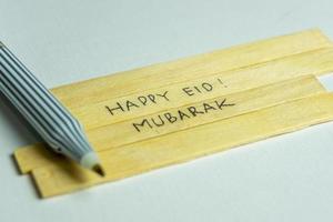 Islamic quotes. Eid Mubarak words written on wooden stick. photo