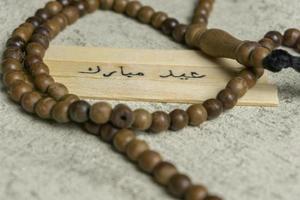 islámico citas. eid Mubarak palabras escrito en de madera palo. foto