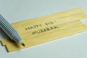 Islamic quotes. Eid Mubarak words written on wooden stick. photo