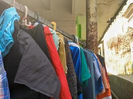 a close up of some clothes drying on a wooden stick outside a house photo