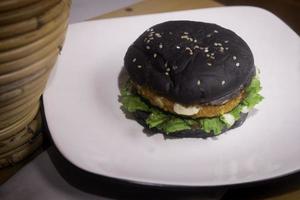 cerca arriba foto de el abrió negro hamburguesa en un blanco plato es muy adecuado para un rápido comida menú