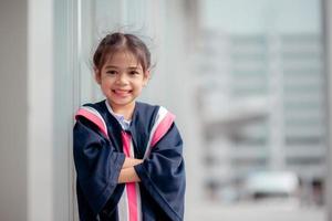 Happy Asian girls in graduation gowns on their graduation day at school.Graduation concept with copy space. photo