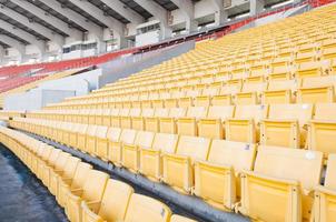 vacío naranja y amarillo asientos a estadio,filas pasarela de asiento en un fútbol estadio foto