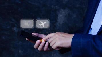 empresario conmovedor teléfono inteligente a Seleccione vuelo por prensado toque pantalla avión botón, negocios avión transporte concepto foto