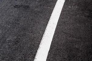 blanco línea en nuevo asfalto detalle,calle con blanco línea textura foto