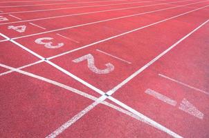 números comenzando punto en rojo corriendo pista, correr pista y verde hierba, directa atletismo corriendo pista a deporte estadio foto