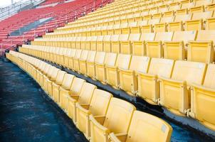 Empty orange and yellow seats at stadium,Rows walkway of seat on a soccer stadium photo