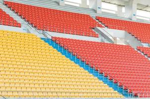 Empty orange and yellow seats at stadium,Rows of seat on a soccer stadium photo