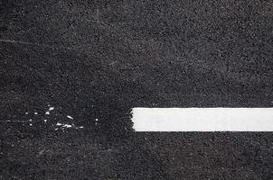 blanco línea en nuevo asfalto detalle,calle con blanco línea textura foto