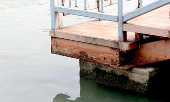 Rusting railing at the pier. Corrosion on white railing, close up view. photo