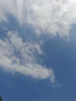 Beautiful white clouds on deep blue sky background. Large bright soft fluffy clouds are cover the entire blue sky. photo