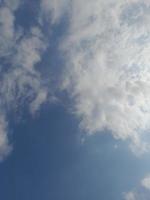 Beautiful white clouds on deep blue sky background. Large bright soft fluffy clouds are cover the entire blue sky. photo