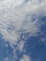 Beautiful white clouds on deep blue sky background. Large bright soft fluffy clouds are cover the entire blue sky. photo