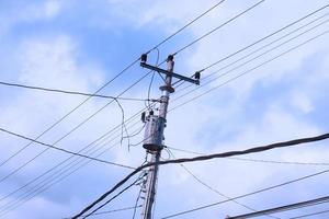 Tangled wire on electric tower against the blue sky background looks so messy photo