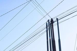 Tangled wire on electric tower against the blue sky background looks so messy photo