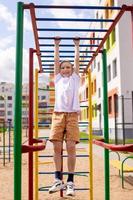 A teenage boy is engaged on horizontal bars near the school photo