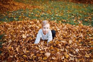 A happy boy stands in the autumn forest photo