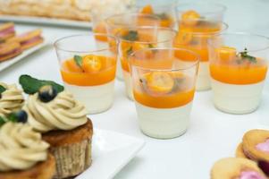 caramelo bar para un fiesta con mollete y crema, Mandarina panna kota en un vaso foto