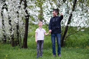 Dad walks with his son and points to the side with his hand and looks at the child photo