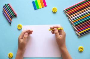 A set of bright stationery on a blue background. Hands holding a ruler photo