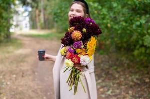 Autumn bouquet of flowers in the hands of a cute girl photo