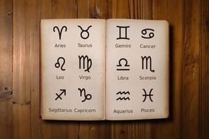 Astrology book filled with zodiac signs on a desk photo