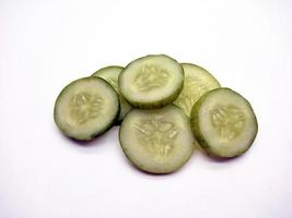 cucumber slices arranged parallel isolated in white background photo