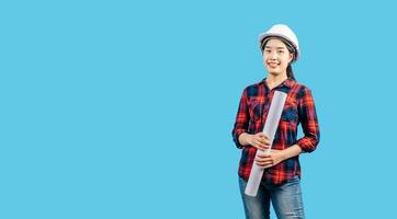 Young female engineer wearing white safety helmet with Blueprints photo