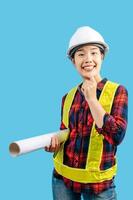 Young asian engineer female wearing safety jacket and helmet hold blue print photo