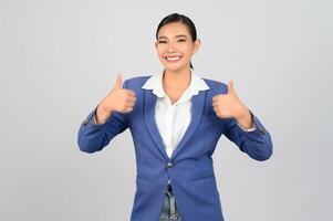 Young beautiful woman in formal clothing for officer with thumb up posture photo