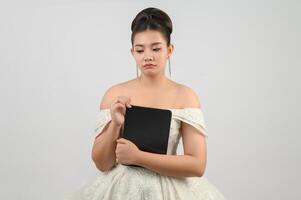 Young asian beautiful bride pose with tablet in hand photo
