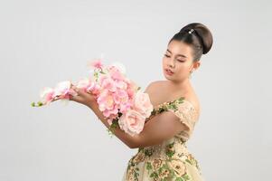 Young asian beautiful bride with orchid bouquet on white background photo