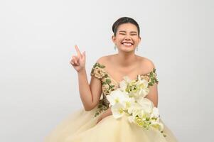 Young asian beautiful bride with orchid bouquet on white background photo