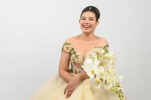 Young asian beautiful bride with orchid bouquet on white background photo