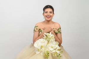 Young asian beautiful bride with orchid bouquet on white background photo