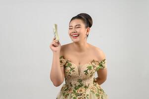 Young asian beautiful bride holding dollar bills in hand photo