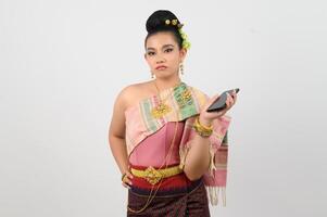 joven hermosa mujer vestir arriba en tailandés del Norte región actitud con teléfono inteligente foto