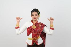 retrato de hermosa tailandés mujer en tradicional ropa pulgar abajo posando foto