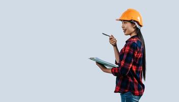 Young female engineer wearing Yellow helmet and clipboard photo